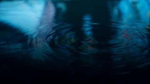 Rain drops falling into puddle on asphalt at night. Raining outside, wet season Stock Footage 127228916