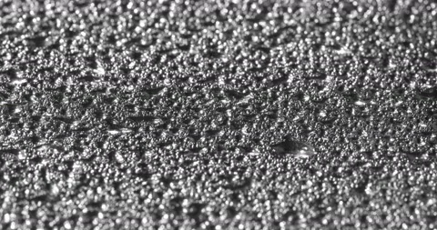 Rain drops falling into puddle on asphalt at night Stock Footage 162276114