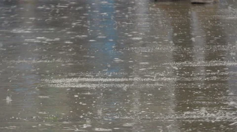 Rain drops falling in puddle on street, reflection of people legs during walk. Stock Footage 61099539