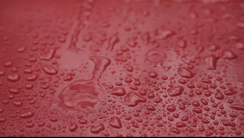 Rain drops falling on red surface 2 big streams Stock Footage 2266761