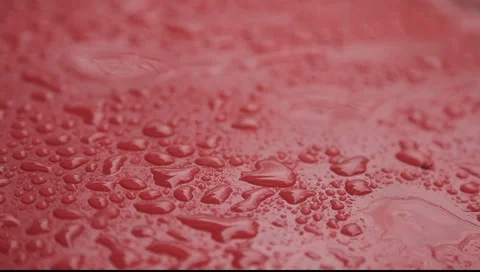 Rain drops falling on red surface big drops Stock Footage 2269064