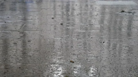 Rain drops falling on a sidewalk. Stock Footage 139048101