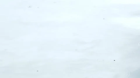 Rain drops falling slowly onto water surface Stock Footage 318032638
