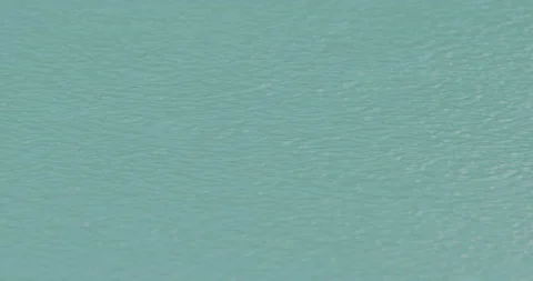 Rain drops falling into torquoise water in slow motion Stock Footage 150643519