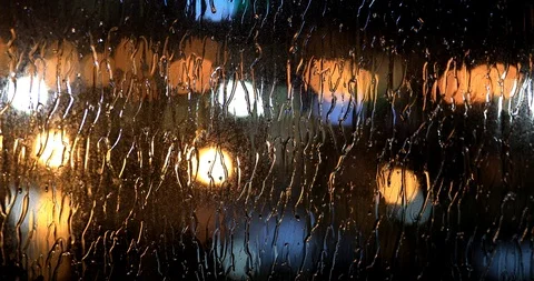 Rain Drops Falling on window with bokeh ... | Stock Video | Pond5