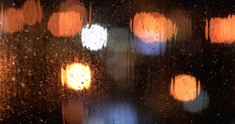 Rain Drops Falling on window with bokeh ... | Stock Video | Pond5