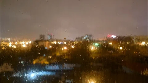 Rain Drops Falling on window with bokeh light effects in the background. Stock Footage 126792799