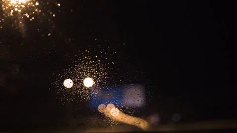 Rain drops falling on a windshield of a car and wipers moving Stock Footage 243572763