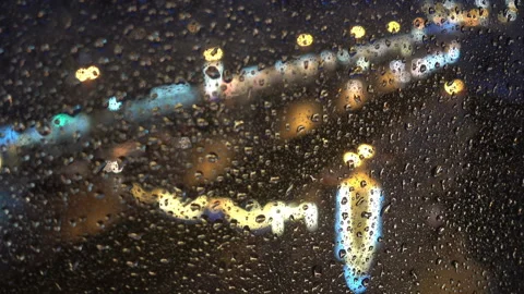 The rain drops flow down the glass on a background of city lights Video stock 137920029