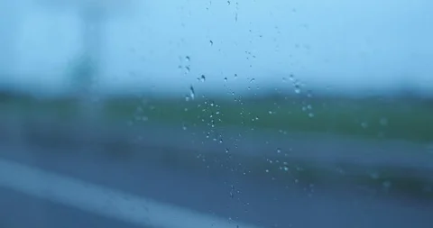 Rain drops on glass car window moving on the road Stock Footage 102998232