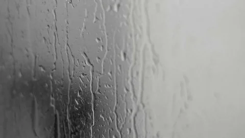 Rain drops on the glass suface of a window with audio. Close-up on rain drops. Stock Footage 99128231