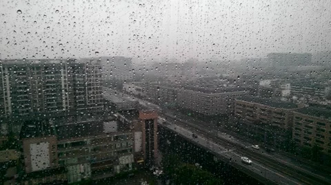 Rain drops on the glass of a window, with defocused buildings and high way Stock Footage 42638028