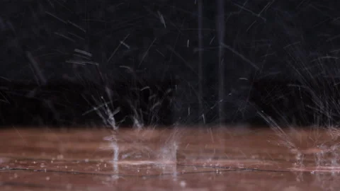 Rain drops hits the floor in the evening. Closeup shot Stock Footage 138446696
