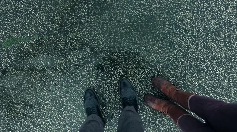 Rain Drops Hitting the Ground with Shoes in the Foreground Stock Footage 62937685