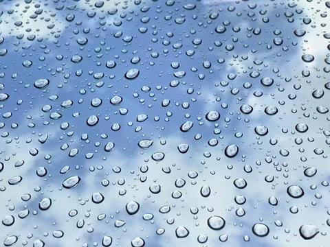 Rain drops at mirror with cloudy blue sky Stock Photos
