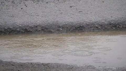 Rain drops on a muddy puddle Stockbeeldmateriaal 153949032