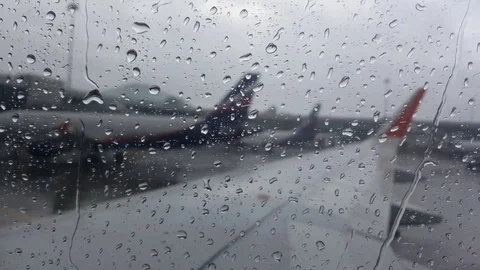 Rain drops on plane window, plane wing, planes in distance Vídeos de archivo 74666350