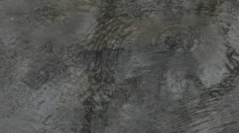 Rain drops rippling across pond water creating texture pattern Video stock 109987