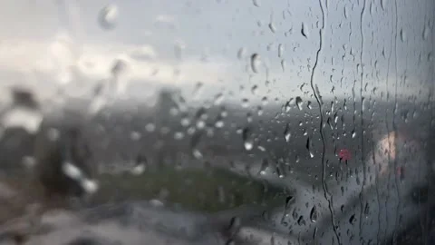 Rain drops rolling down on the window with highway and traffic at the background Stock Footage 211681547