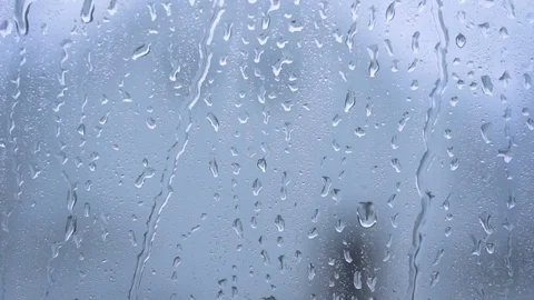 Rain drops running down a window pane. Blue tint blurred background Stock Footage 78518301