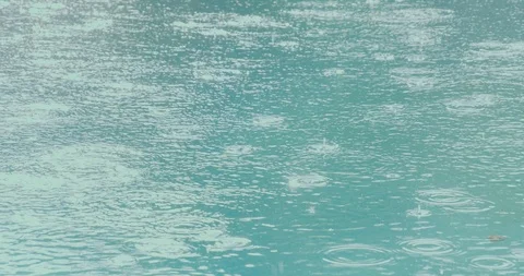 Rain drops in slow motion on clear blue water Stock Footage 101122531