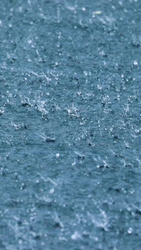 Rain drops splashing on water surface in vertical motion. Stock Footage 346393788