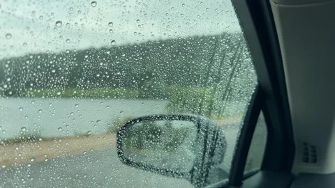Rain drops streaming down a car window during a downpour. Side mirror visib.. Stock Footage 340545851