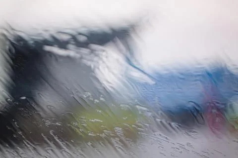 Rain Drops On Surface of wet Window Glass pane In Rainy Season. Abstract Stock Photos