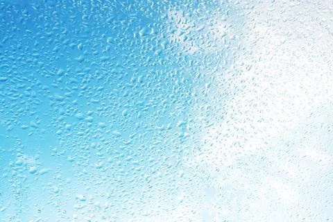 Rain drops on surface of the window glass with sky cloud background. Natural  Stock Photos