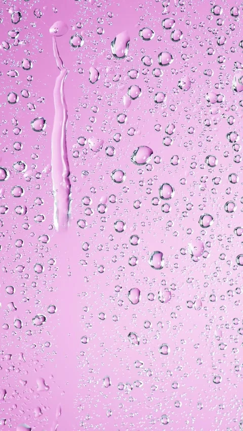 Rain drops trickling down on pink background. Water drops falling on window.. Stock Footage 307304978