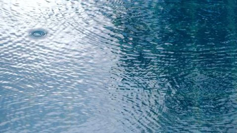 Rain drops on the water pool Stock Photos