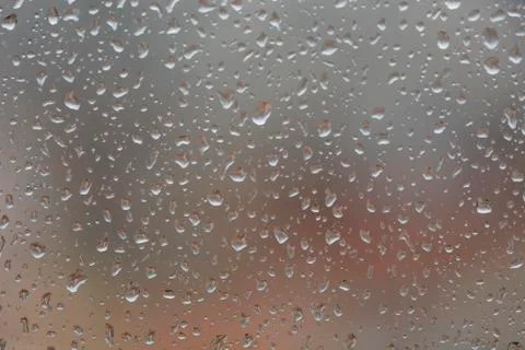 Rain drops on window, against blurry background of a town Stock-Fotos