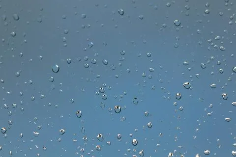 Rain drops on a window against a thundery gray sky Stock Photos