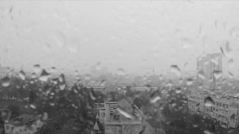 Rain drops on window and city outside black and white Stock Footage 82367641