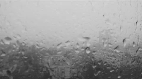 Rain drops on the window and the city outside black and white Stock Footage 82370559