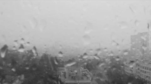 Rain drops on window and the city outside black and white Stock Footage 82370844