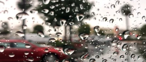Rain drops on the window with blur traffic in the background Stock Footage 99437530