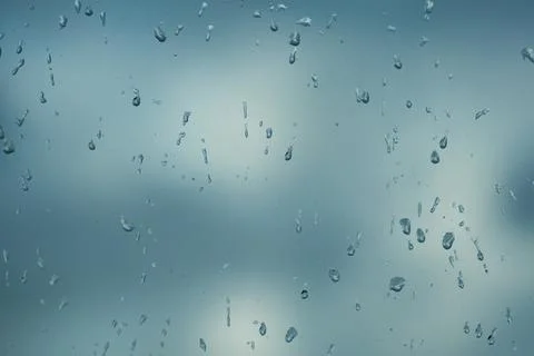 Rain drops on window with blured gray background. Seasonal background texture Stock Photos