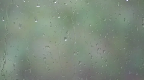 Rain drops on a window with blurred trees behind Stock Footage 68728522