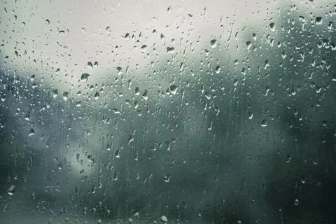 Rain drops on a window with blurry background Stock Photos