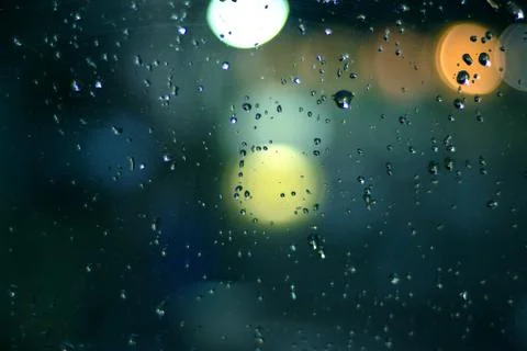 Rain drops on window with bokeh on blure background Stock Photos