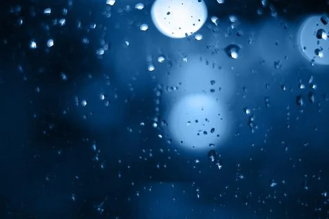Rain drops on window with bokeh on blure background Stock Photos