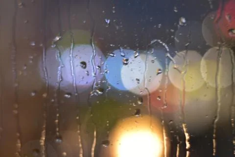 Rain drops on window with bokeh effect  Stock Photos