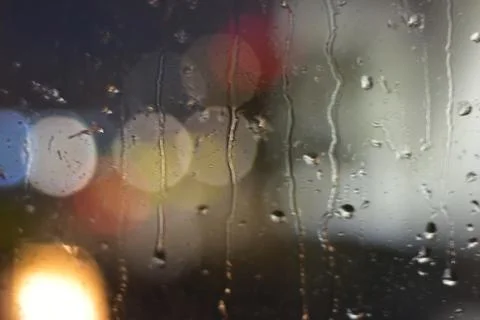 Rain drops on window with bokeh effect  Stock Photos