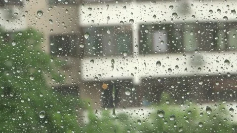 Rain drops on window with building in background Stock Footage