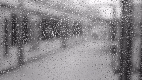 Rain drops on a window bus stop in black and white Stock Footage 117931577