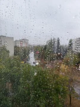 Rain drops on window with city in background Stock Photos