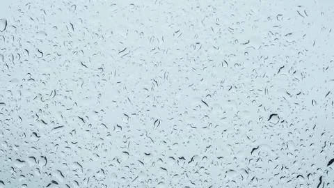 Rain drops on window in cloudy sky background Stock Photos