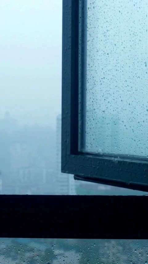 Rain drops on window glass with city background blur Stock Footage 331933798