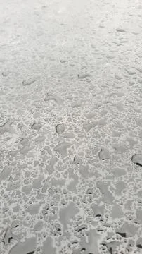 Rain drops on window glasses surface with cloudy background Stock Photos